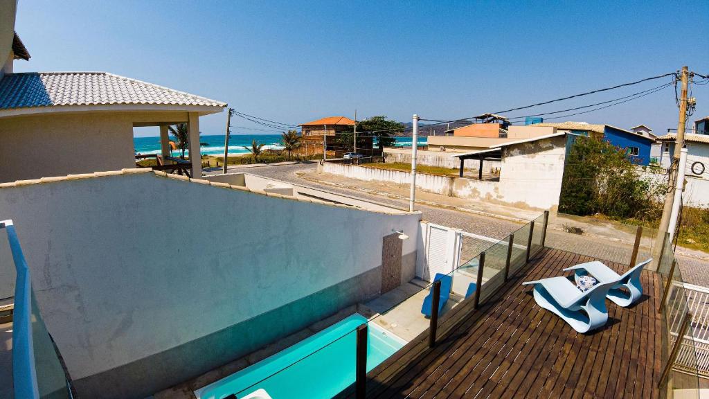 a balcony with a view of the ocean from a house at Casa Blanca Foguete 3 suítes Praia Lagoa SPA aquecido Piscina in Cabo Frio
