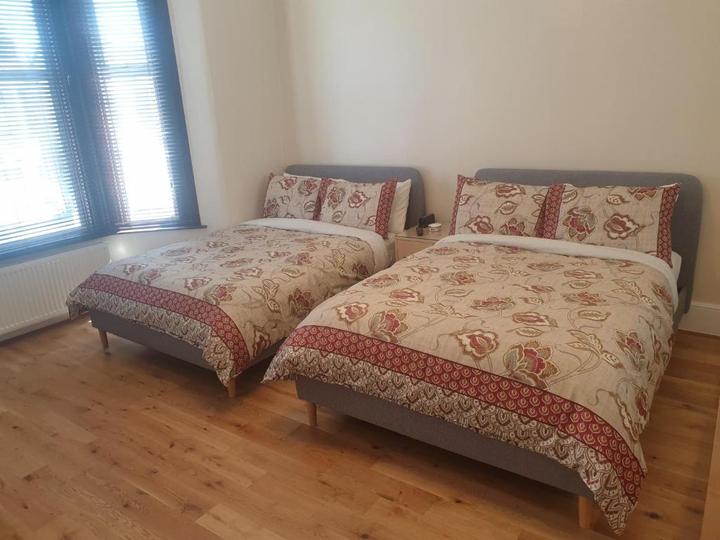 1 dormitorio con 2 camas y 2 almohadas en London Luxury 2 Bedroom Apartment 5 min from tube station with free parking, en Wanstead