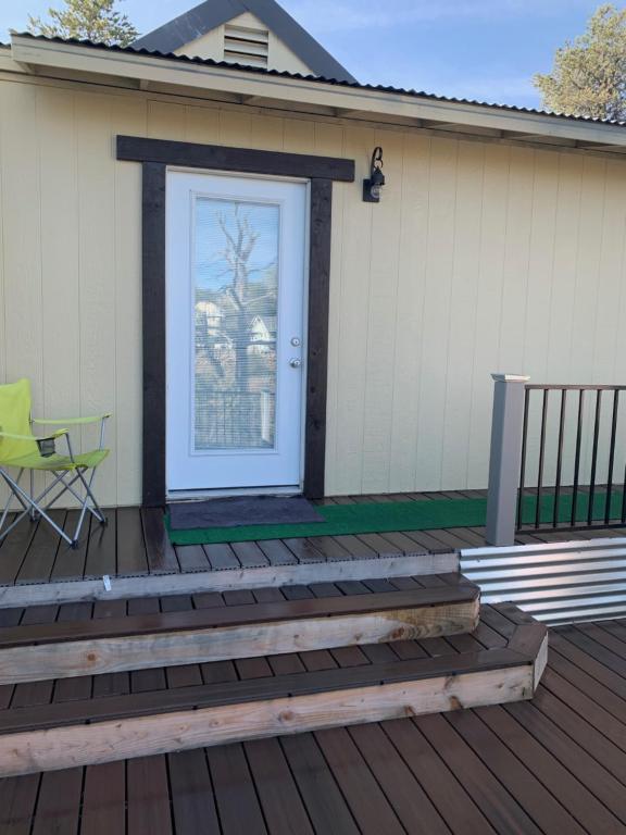 una terraza con una puerta blanca y una silla verde en Cozy Guesthouse with view from large deck en Prescott