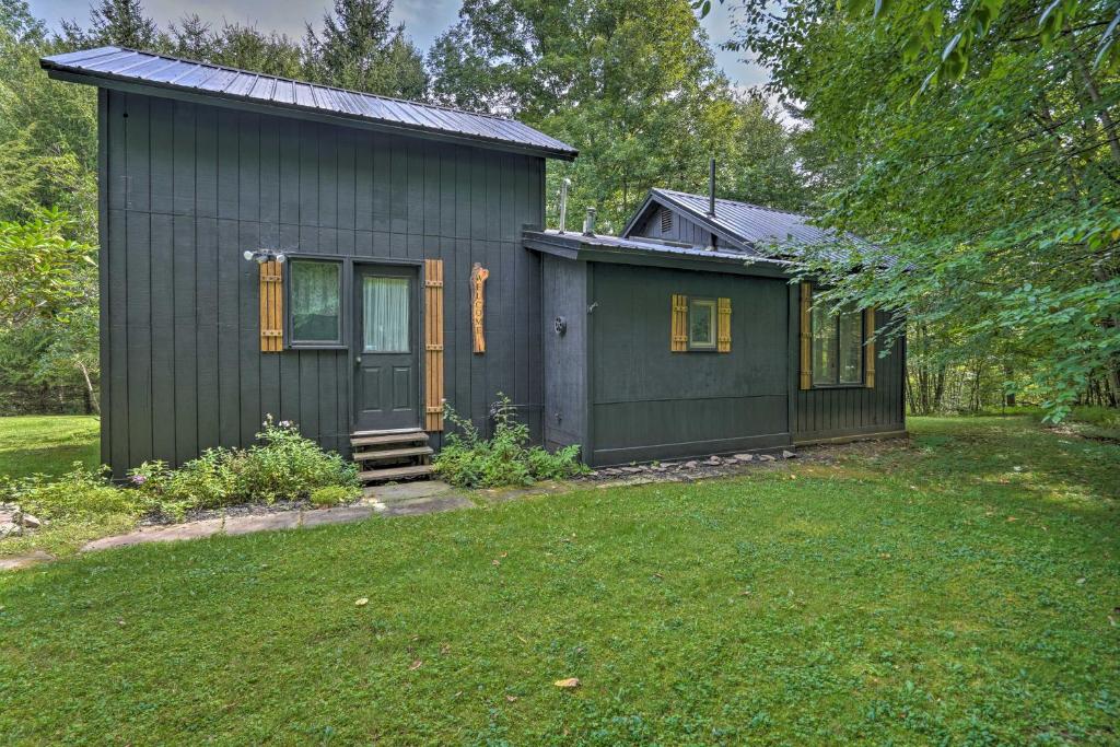 una piccola casa nera con un cortile di Rustic Unadilla Cottage on 15 Acres with Pond! a Unadilla