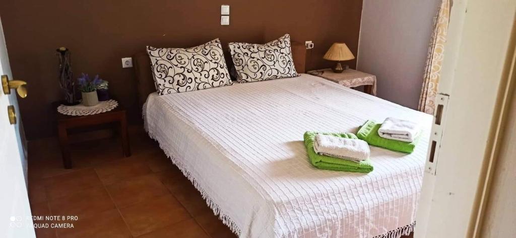 a bedroom with a large bed with green towels on it at Villa Freedom - Koutsoubri Beach Evia in Agriovótanon