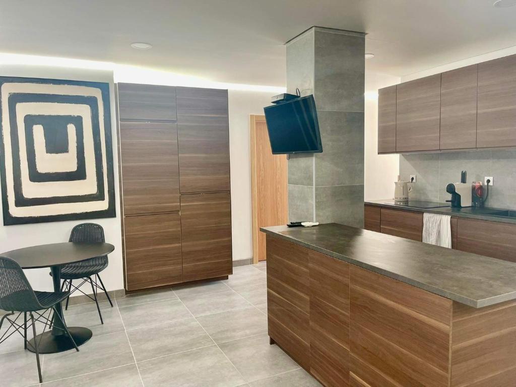 a kitchen with a counter and a table with chairs at Pontinha Exclusive House in Faro