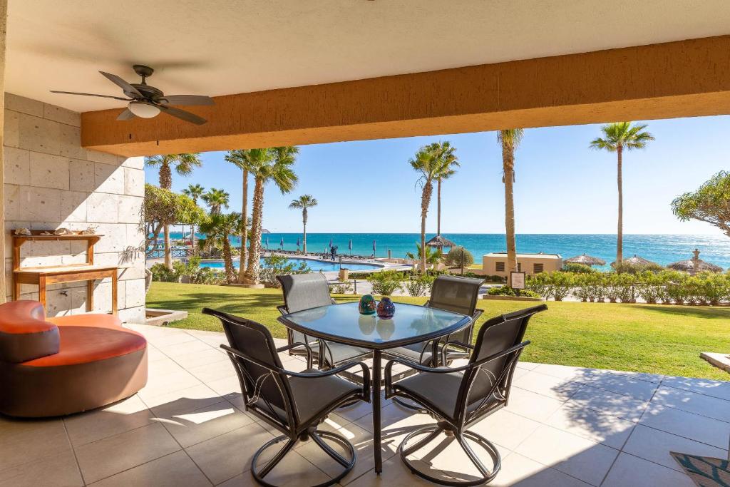un patio con mesa, sillas y el océano en Sonoran Sun Ground Floor - 104-W en Puerto Peñasco