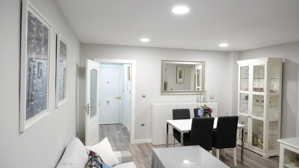 a white living room with a table and chairs at Slappe Jaén I in Jaén