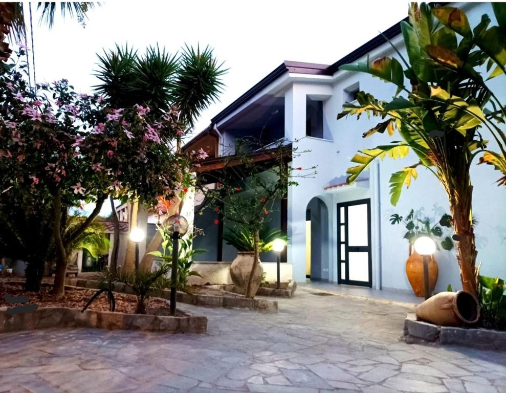 une maison avec des palmiers devant elle dans l'établissement Eraclea Minoa Apartments, à Eraclea Minoa