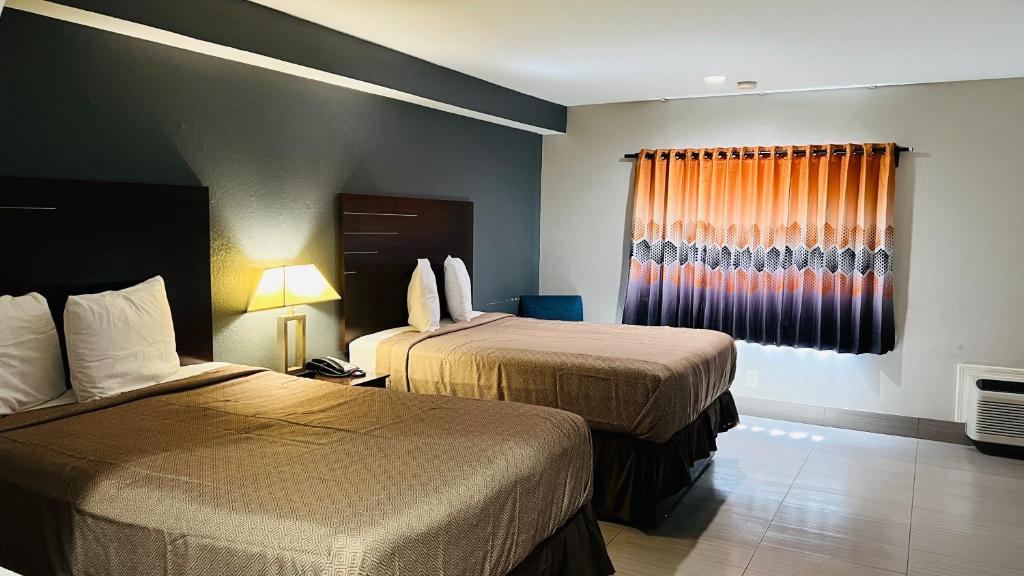 een hotelkamer met 2 bedden en een raam bij REGENCY INN & SUITS in Houston