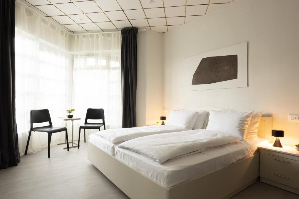 1 dormitorio con 1 cama blanca, mesa y sillas en Apartments Trzin-Mlake w FREE Parking, en Trzin