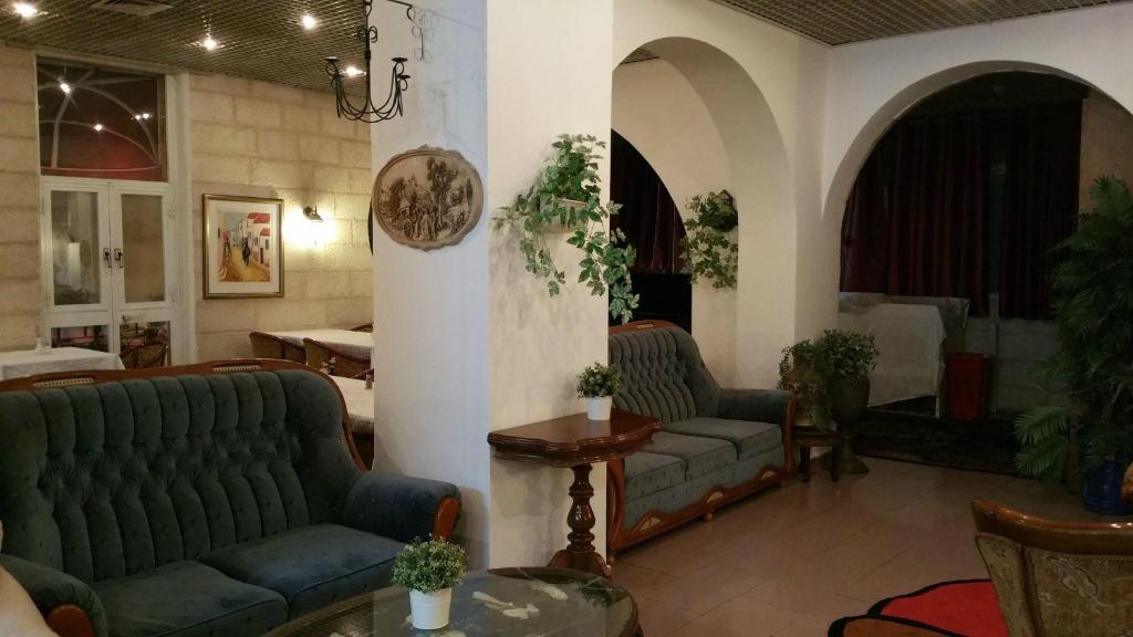a living room with two couches and a table at Zion Hotel in Jerusalem