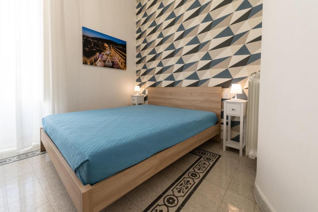 a bedroom with a bed and a checkered wall at Casa Melina in Scicli