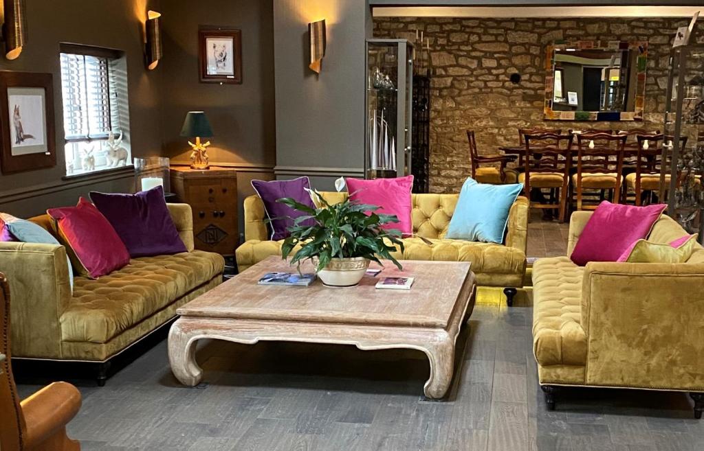 a living room with couches and a coffee table at Pettifers Freehouse Hotel in Crudwell