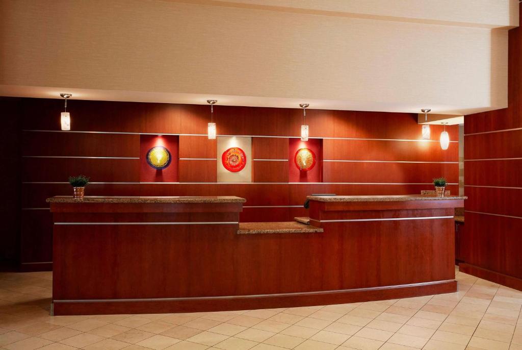 a lobby with red walls and a counter with lights at Wyndham Cleveland Airport in Cleveland