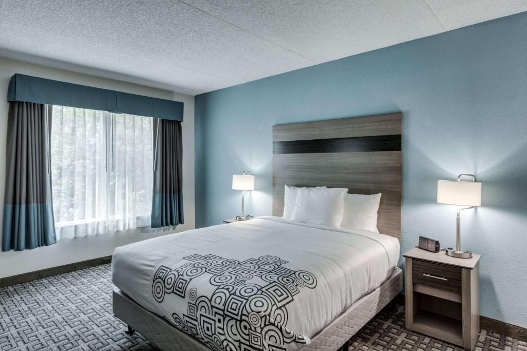 a hotel room with a large bed and two lamps at Days Inn & Suites by Wyndham Spokane in Spokane