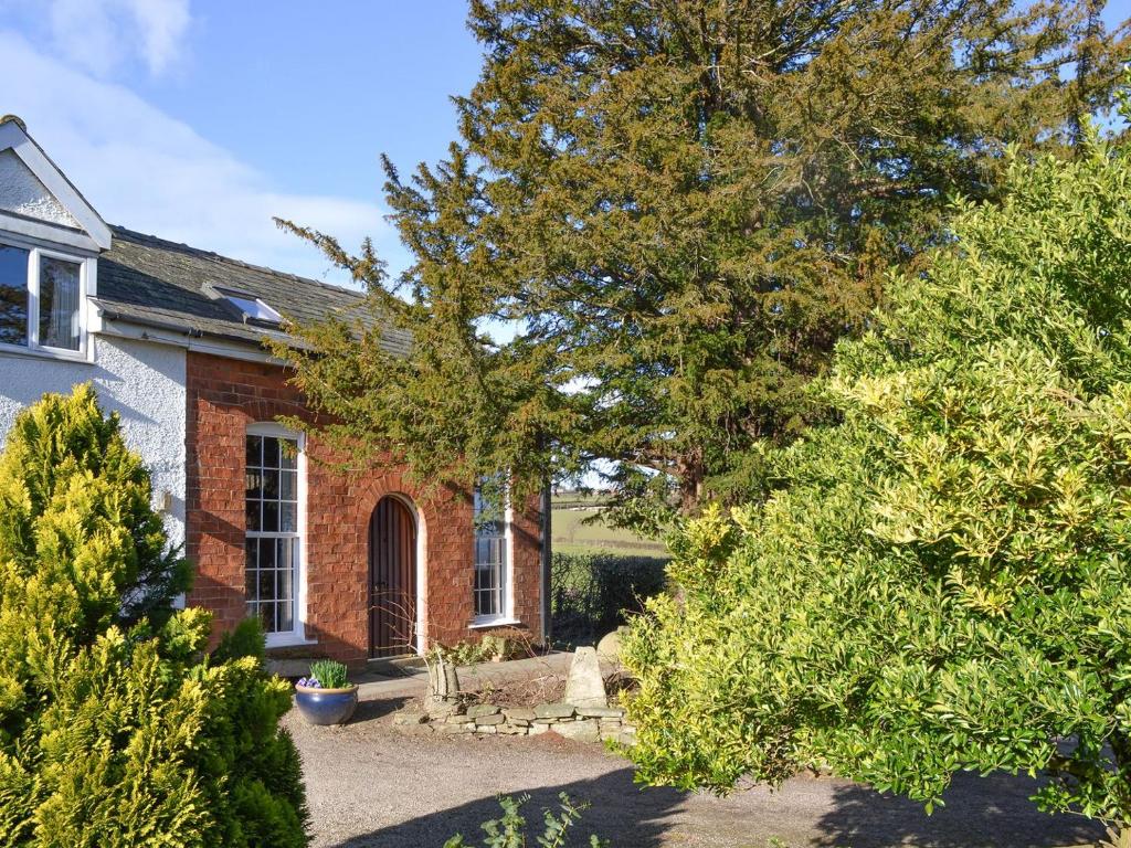 a brick house with trees in front of it at Orchard Chapel in Much Marcle