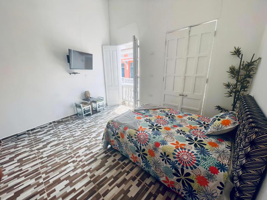 um quarto com uma cama e uma televisão em Hostal Badillo SV em Cartagena das Índias