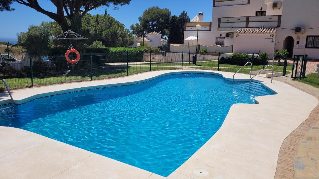 a pool with blue water in front of a building at Casa Maryna Calahonda by Casa del sol Holiday Rentals in Sitio de Calahonda