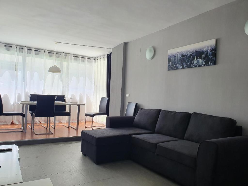 uma sala de estar com um sofá e uma mesa com cadeiras em Sunny apartment Benidorm em Cala de Finestrat