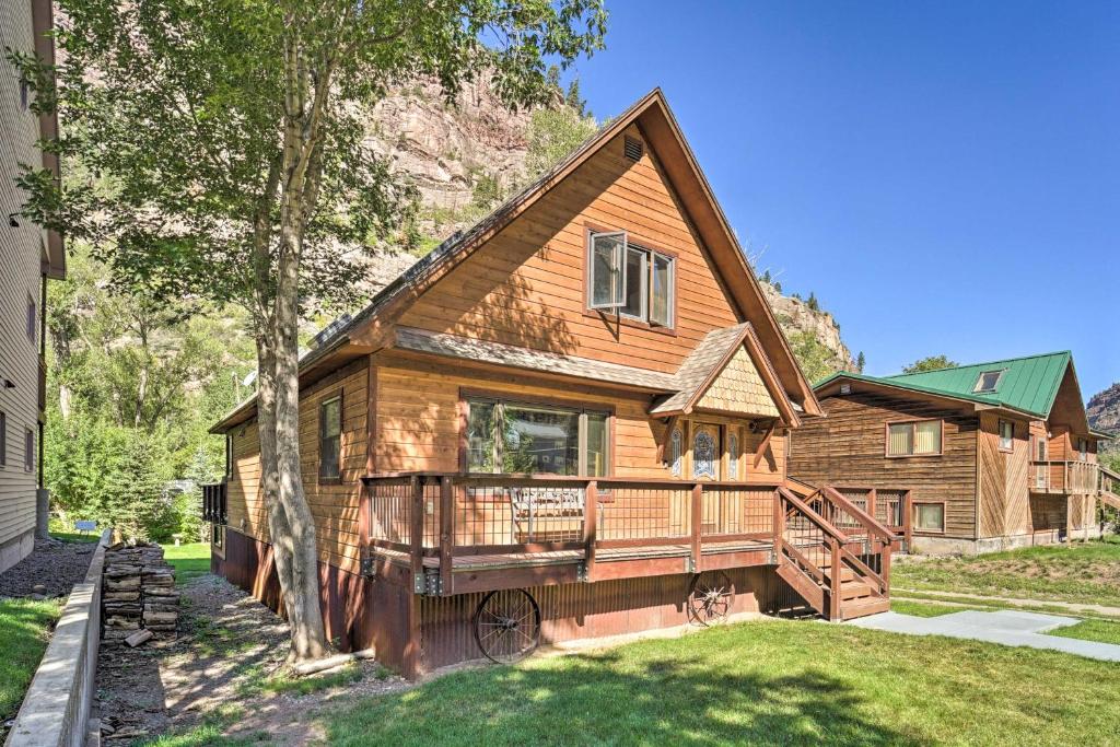 a log home with a porch and a deck at Updated Mtn Home with Deck on Uncompahgre River in Ouray