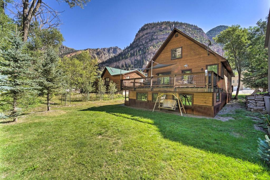 an image of a log home with mountains in the background at Updated Mtn Home with Deck on Uncompahgre River in Ouray