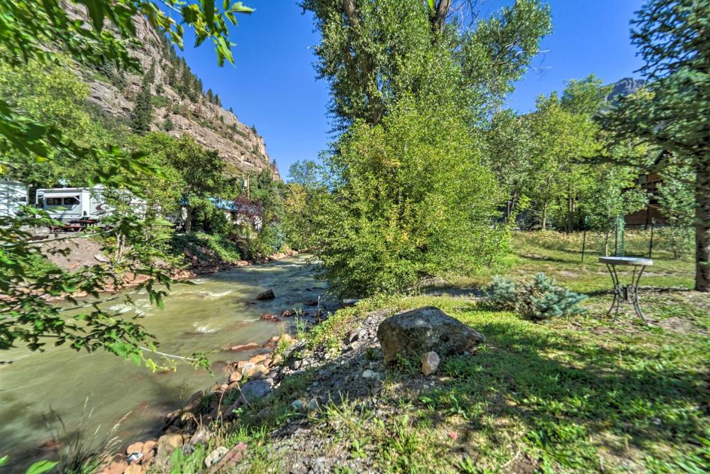 a river with a campsite and trees on the side at Updated Mtn Home with Deck on Uncompahgre River in Ouray