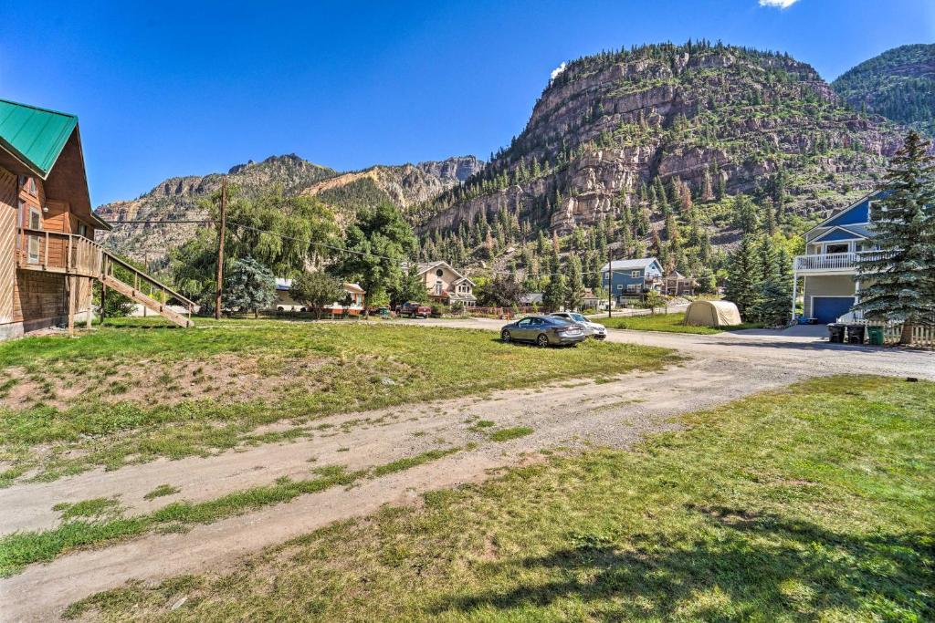 a car parked on a dirt road in front of a mountain at Updated Mtn Home with Deck on Uncompahgre River in Ouray