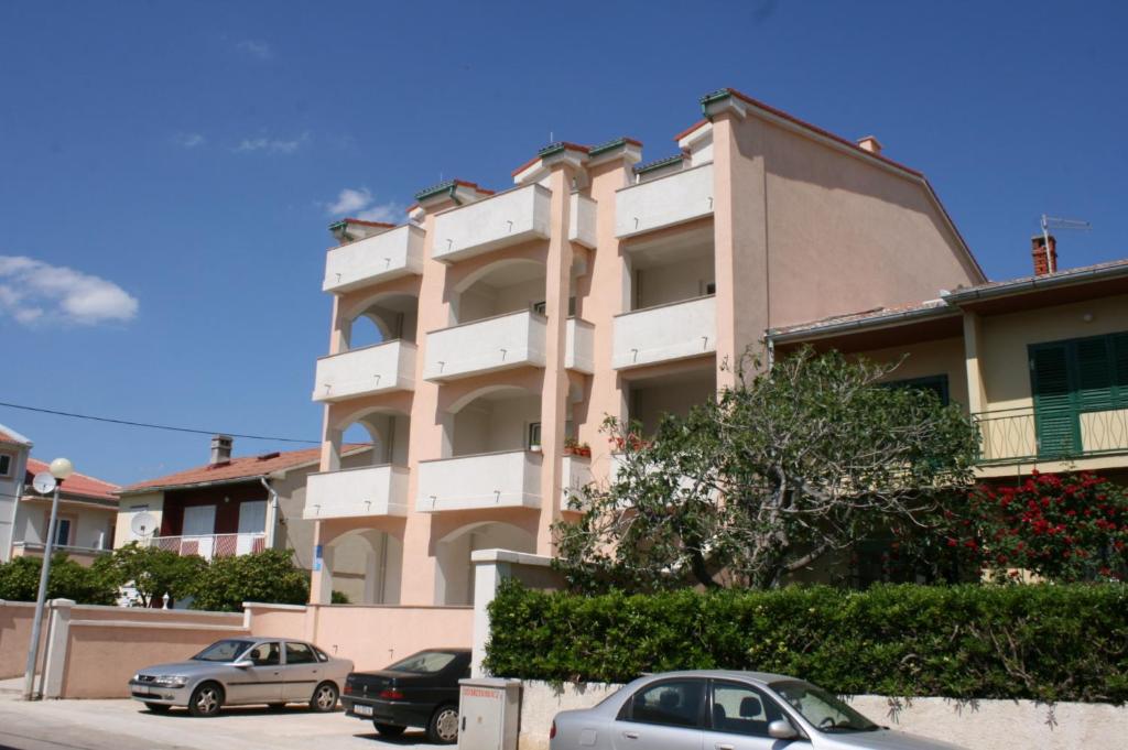 a building with cars parked in front of it at Double Room Pag 6311b in Pag