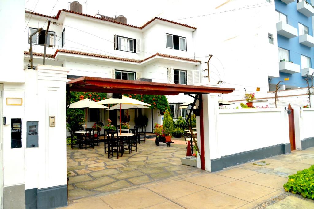 a patio with tables and umbrellas in front of a building at Residencial Carlos in Lima