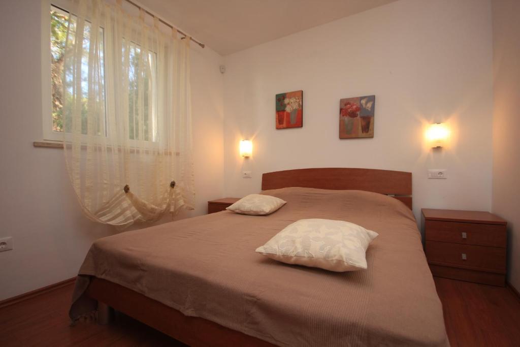 ein Schlafzimmer mit einem Bett mit zwei Kissen darauf in der Unterkunft Apartments by the sea Rovinj - 3373 in Rovinj