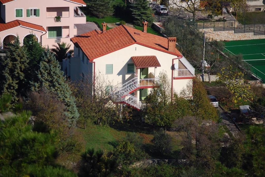 Biały dom z czerwonym dachem na wzgórzu w obiekcie Apartment Labin 7468a w mieście Labin