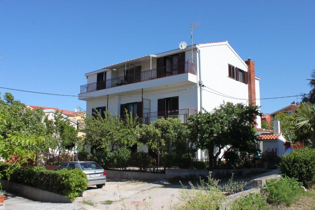 a white building with a car parked in front of it at Apartments with a parking space Vodice - 7604 in Vodice