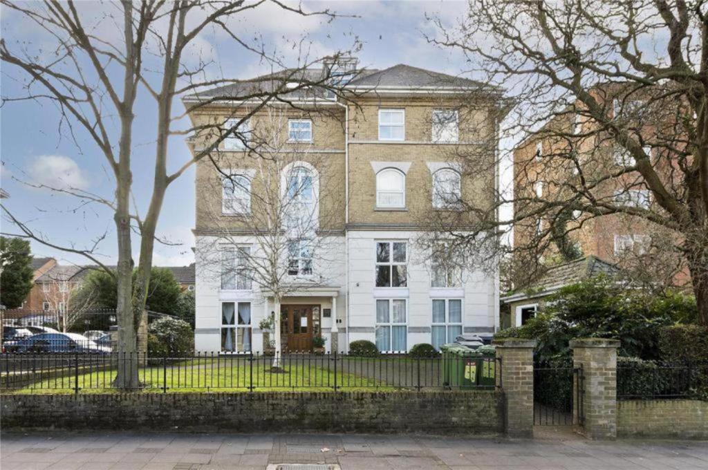 a large white house with a fence in front of it at Remarkable 2-Bedroom Apartment with an EnSite in London