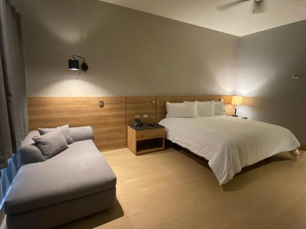 ナボホアにあるRIVI GRAND HOTELのベッドとソファ付きのホテルルーム