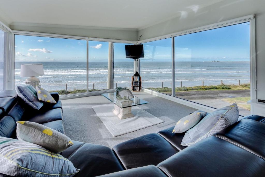 a living room with a couch and a view of the ocean at Sandy Cove in Port Fairy