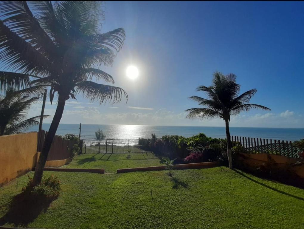 una casa con palmeras y vistas al océano en Atlântico Flat - Apto 004 en Natal
