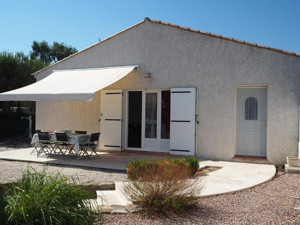 una casa con un tavolo e un ombrello bianco di Ground floor holiday home with modern design, Montagnac a Montagnac
