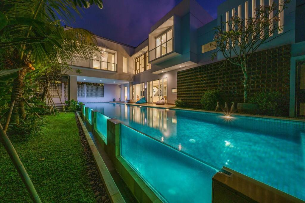 チャングーにあるVilla Ammanya - Modern 3-bedroom luxury villa in amazing location!の夜の家の前のプール