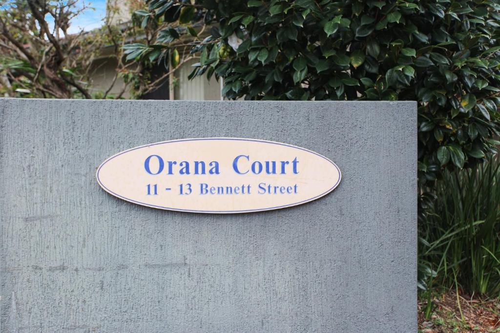 a sign for an oana court on a wall at One Street Back from the Surf Beach in Hawks Nest