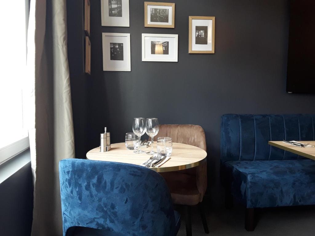 拉尚赫蒂的住宿－La Pomme d'Or，餐厅里一张桌子,上面摆放着酒杯和蓝椅