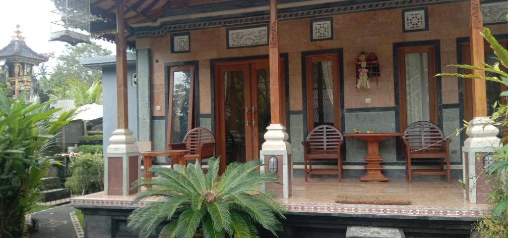 dom z krzesłami i stołem przed nim w obiekcie Khailash Warung and Home Stay w mieście Sidemen