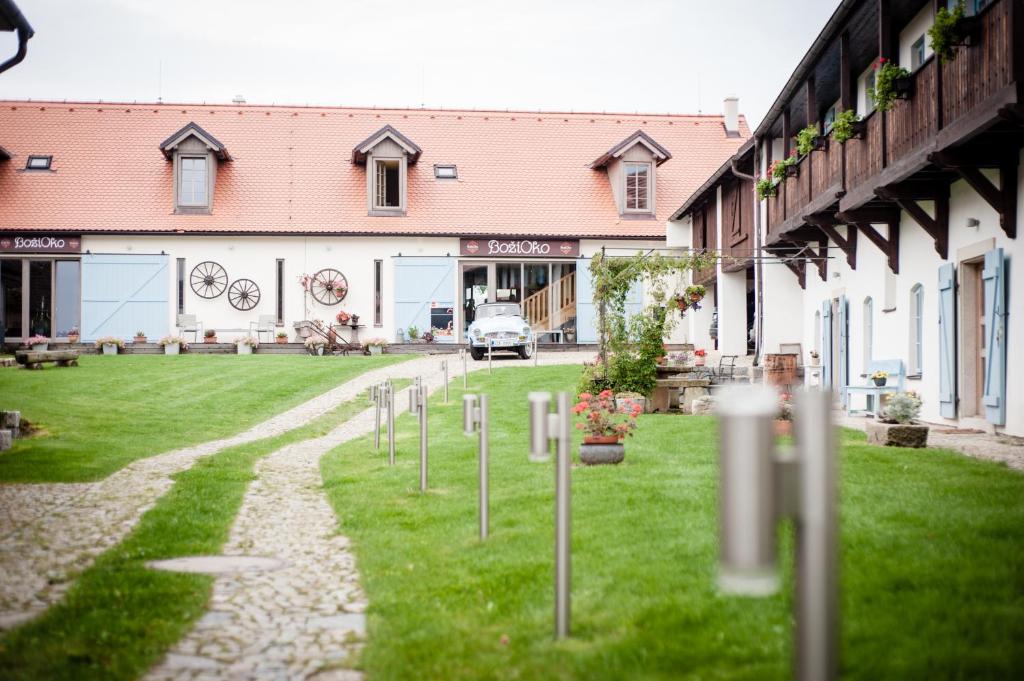 a row of poles in the grass in front of a building at Wellness Hotel Boží oko in Malé Chrášťany