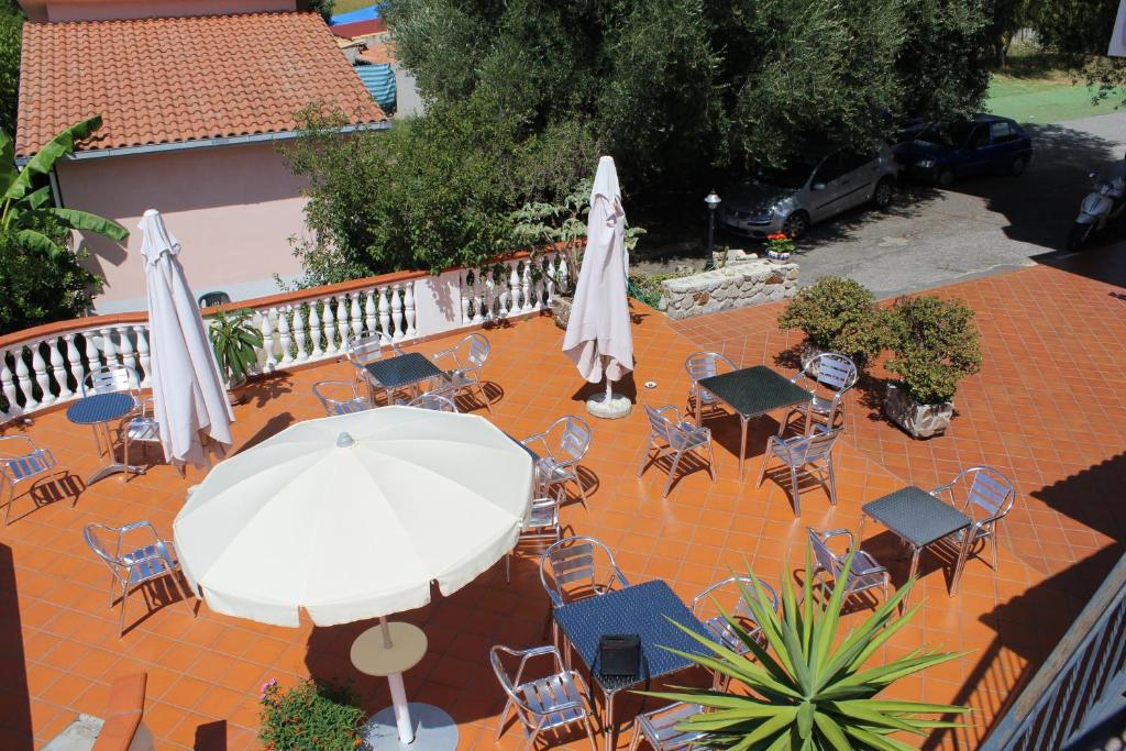 a patio with a table and chairs and an umbrella at Hotel Royal in Coccorino