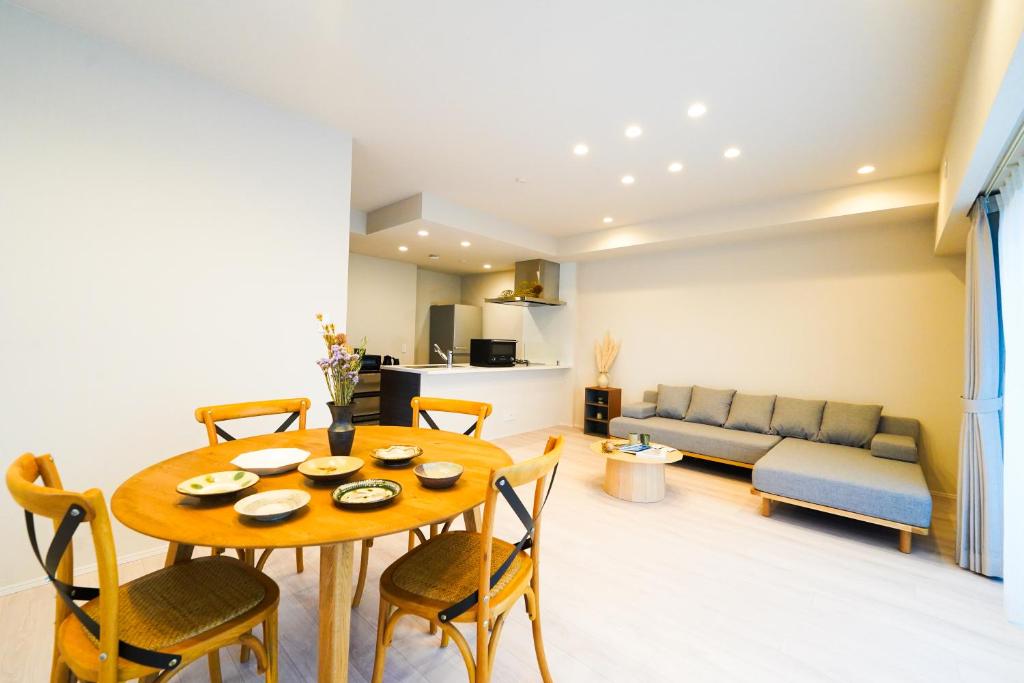 a living room with a table and chairs and a couch at Branchera Naha 1405 in Naha