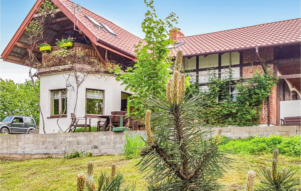 a house with a tree in front of it at Gorgeous Home In Lidzbark Warminski With House Sea View in Lidzbark Warmiński