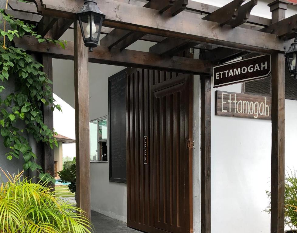 een toegang tot een gebouw met een houten deur en straatborden bij Ettamogah Hotel Inc. in Malino