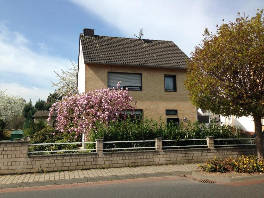 uma casa com flores cor-de-rosa em frente em Gästehaus Peterhoff em Düren - Eifel