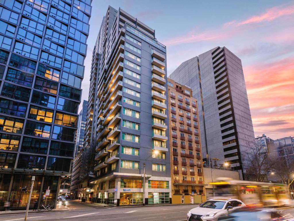 a city with tall buildings and a street with cars at Brady Apartment Hotel Flinders Street in Melbourne