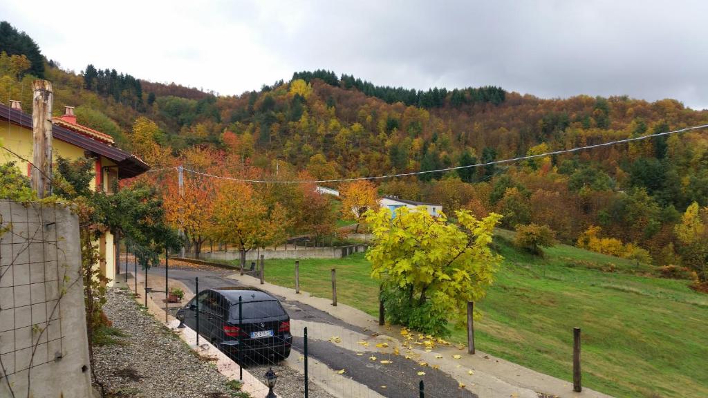 una macchina nera parcheggiata in una strada accanto a una casa di Agriturismo Pietro Falcone a Celico
