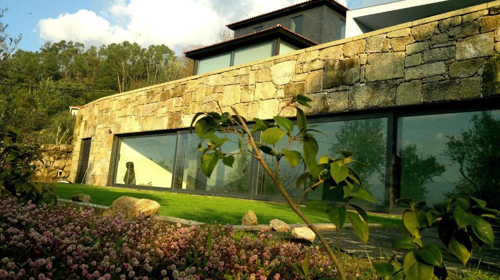 シンファンイスにあるArsDurium Douro hotelの大きな窓のある庭園の石造りの家