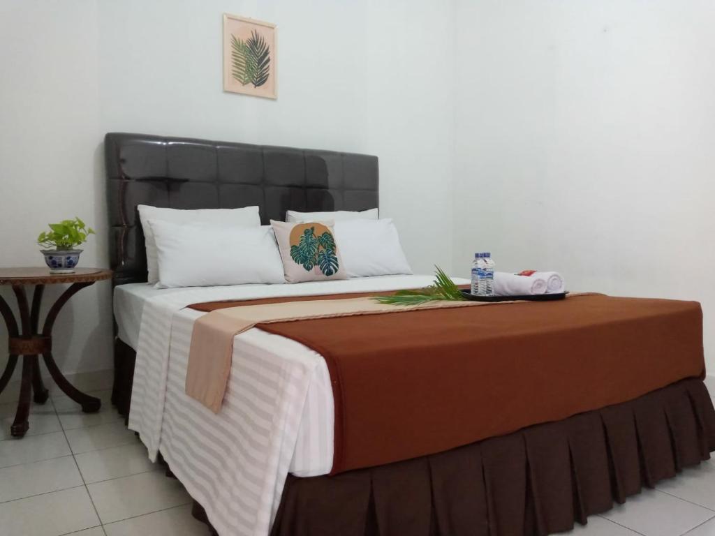 1 dormitorio con 1 cama grande y 1 mesa en New Hotel Kayu Manis, en Timuran