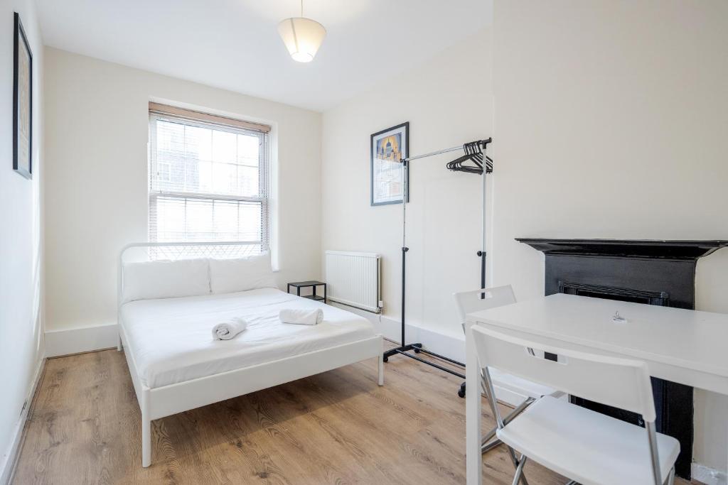 a white living room with a white couch and a desk at APlaceToStay Central London Apartment, Zone 1 KIN in London