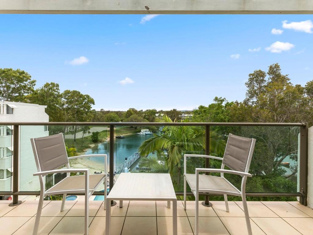 a balcony with chairs and a view of a river at 21 1 Quamby Place Noosa Heads in Noosa Heads